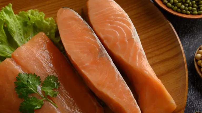 Filés de salmão cru e fresco, a principal matéria-prima e o maior custo (CMV) de um rodízio japonês, dispostos em uma tigela de madeira.