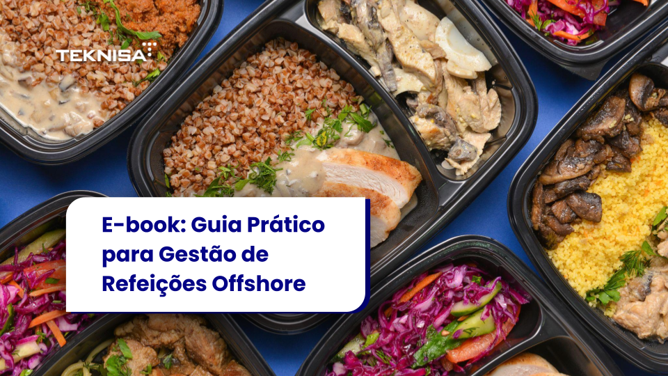 Vista superior de varias fiambreras negras dispuestas una al lado de la otra, que contienen diferentes comidas con arroz, cereales, carne, verduras y ensaladas de colores como col lombarda y zanahorias, dispuestas sobre un fondo azul.