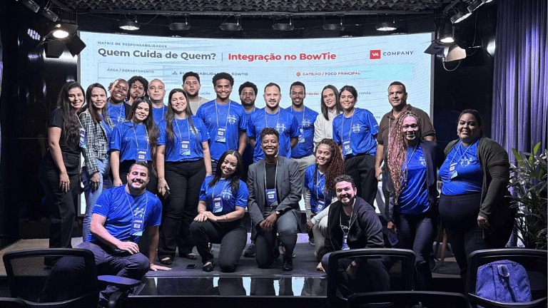 Grupo de colaboradores da Teknisa e a palestrante Bruna Procópio reunidos no palco do TekWeek 2026 em frente a um telão sobre integração no BowTie.